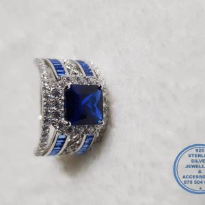925 Sterling Silver Ring Showstopper Of Note. Large Halo Blue Square in middle with side curl band detail and 2 rows of blue baguettes down sides with clear cubic detail. Must Have