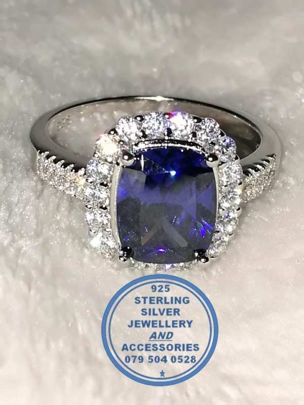 "925 sterling Silver Ring with Large Blue Rectangular cubic with clear cubics all around and going down on sides of this ring"