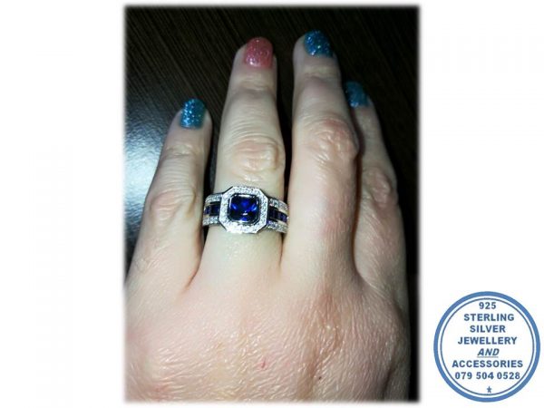 925 Sterling Silver Ring with Extra  Large Blue Rectangular cubic with clear cubics all around and going down on sides of this ring. Middle Blue Baguettes